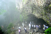 参加者が、笙ノ窟の下に集まり、洞窟内を見ている様子を上から写した写真