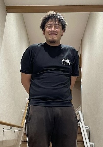黒いTシャツ姿の土居 甚太さんを下から撮影した写真