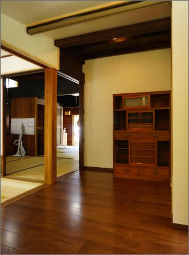 奥の和室へと続く、和箪笥が設置された艶やかな木目調の廊下の写真